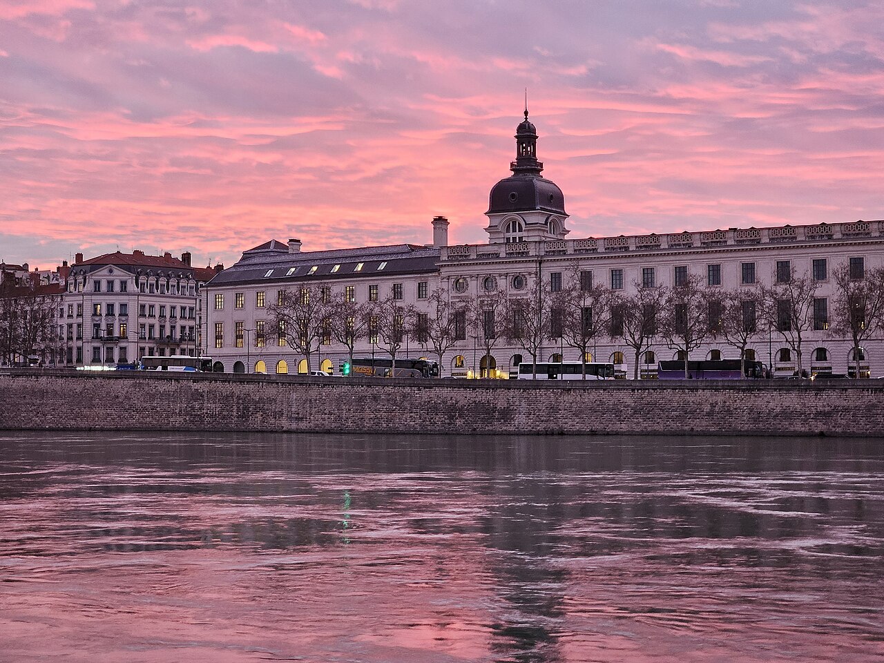 Pink and purple sunset over Lyon’s riverside buildings, reflected in the Rhône.